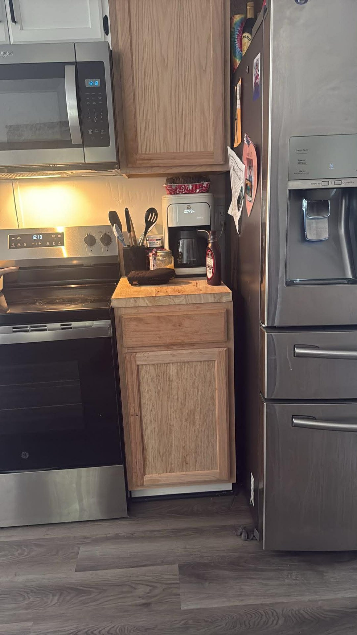 New unfinished wood base cabinet with butcher block top installed between a range and refrigerator